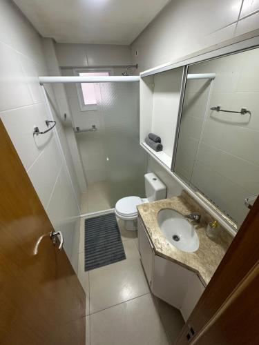 ein Badezimmer mit Waschbecken, Toilette und Spiegel in der Unterkunft Melhor apartamento de capão! 100m da praia in Capão da Canoa