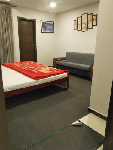 a room with a bed and a couch in it at Afzal real estate builder's in Islamabad