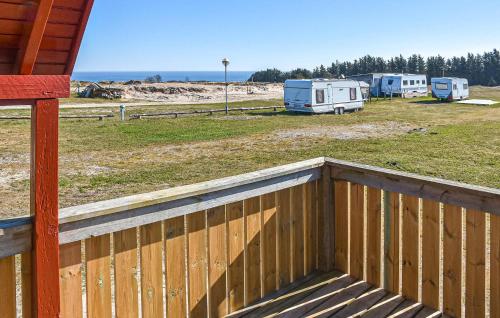 a wooden fence next to a yard with two rvs at Amazing Home In Hanstholm With Private Swimming Pool, Can Be Inside Or Outside in Pugdal