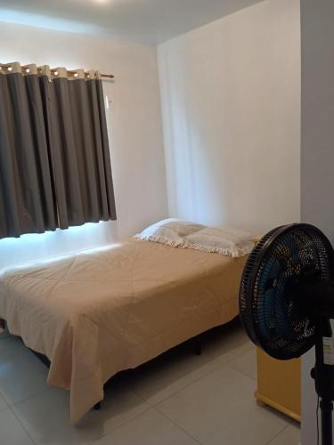 a bedroom with a bed and a window with a fan at Casa com visto para o Cristo e cidade in Encantado