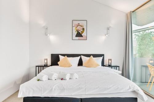 ein weißes Schlafzimmer mit einem großen weißen Bett mit Kissen in der Unterkunft Penthouse Panorama Deluxe - Seesicht - BBQ - Beach Paradise - Loft Premium in Öhningen