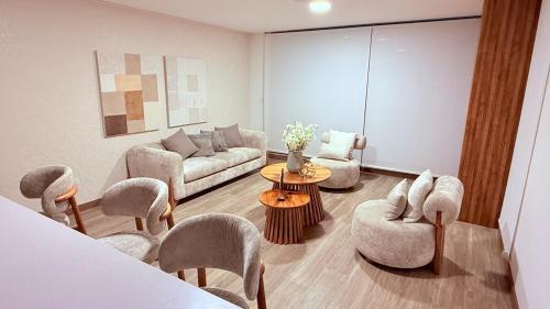 un soggiorno con un divano, sedie e un tavolo di Departamento 2 dormitorios Quiteño Libre a Quito