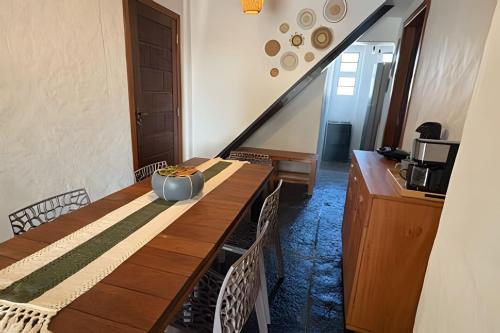 een eetkamer met een houten tafel en een trap bij Casa Monan, Atins beach in Atins