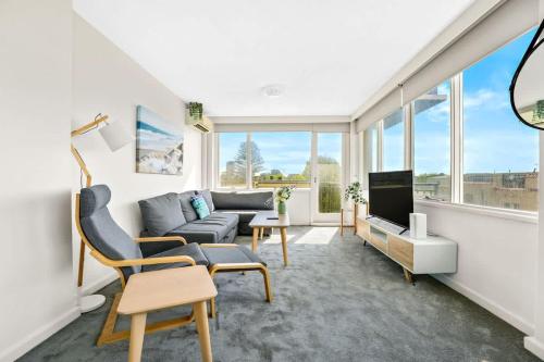 a living room with a couch and a tv at Brightly Renovated St Kilda Apt with Sea Views in Melbourne