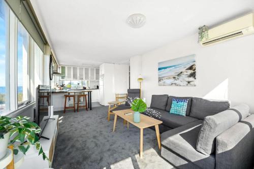 a living room with a couch and a table at Brightly Renovated St Kilda Apt with Sea Views in Melbourne