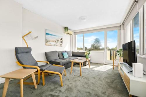 a living room with a couch and a tv at Brightly Renovated St Kilda Apt with Sea Views in Melbourne