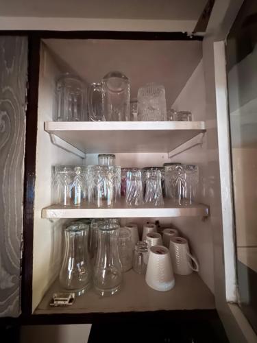 un estante lleno de frascos y botellas de vidrio en Homely, Secured, Privacy at Prime Location, en Vadodara