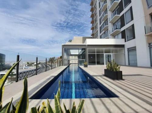 a house with a swimming pool in front of a building at Luxury apartment with panoramic view in tower in Laborcillas