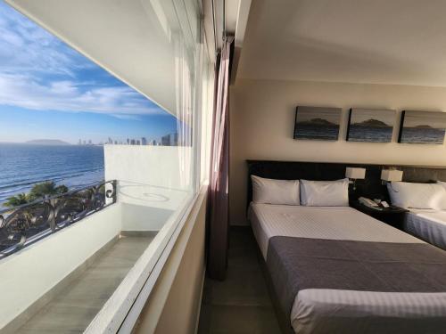 马萨特兰Hacienda Mazatlán sea view的一间有两张床、可欣赏海景的酒店房间