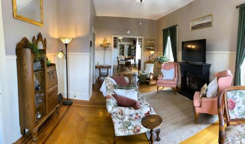 een woonkamer met een bank en stoelen bij Historic Victorian Apartment in McGregor