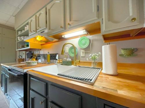 een keuken met witte kasten en een houten aanrechtblad bij Historic Victorian Apartment in McGregor