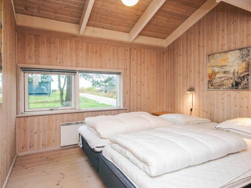 1 Schlafzimmer mit 2 Betten an einer Holzwand in der Unterkunft 8 person holiday home in Ebeltoft-By Traum in Ebeltoft