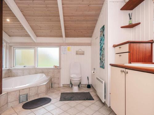 ein Badezimmer mit Badewanne, Toilette und Waschbecken in der Unterkunft 8 person holiday home in Ebeltoft-By Traum in Ebeltoft