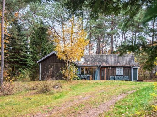 Una casa en el bosque con un camino de tierra al frente. en 7 person holiday home in Kolind-By Traum, en Kolind