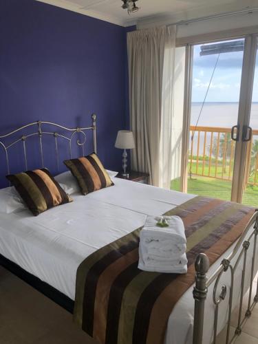 ein Schlafzimmer mit einem Bett mit Blick auf das Meer in der Unterkunft Coral Towers Holiday Suites in Cairns