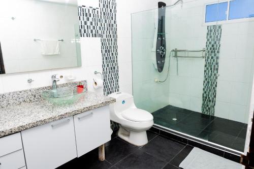 a bathroom with a toilet and a glass shower at Departamento Bocagrande cerca a playas in Cartagena de Indias
