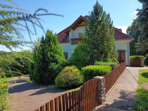 a fence in front of a house with trees at Rezidence Jih in Hlavňovice