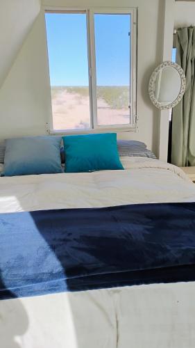 a bedroom with a large bed with a window at Arlo's AFrame in Joshua Tree