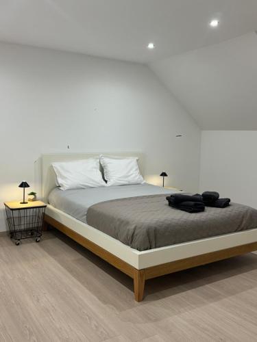 a white bedroom with a large bed with two lamps at Chambre Élégance et confort a Esch in Esch-sur-Alzette
