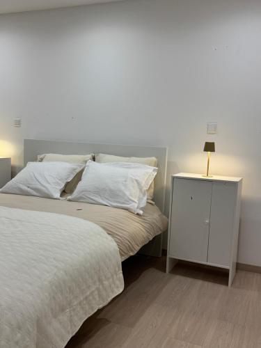 a bedroom with a white bed and a night stand at Chambre Élégance et confort a Esch in Esch-sur-Alzette