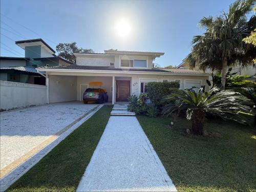 ein Haus mit einem davor geparkten Auto in der Unterkunft Casa Riviera Prime in Colônia de Férias