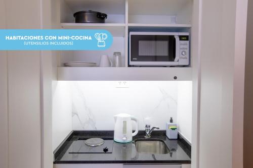 a small kitchen with a sink and a microwave at El Misti Coliving Obelisco in Buenos Aires