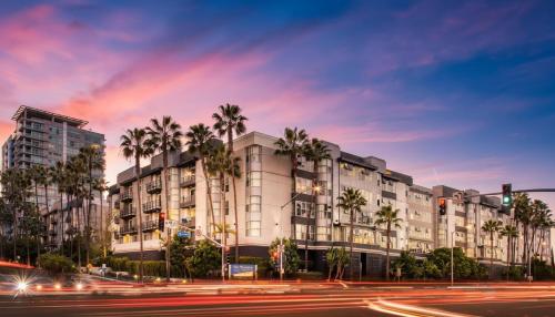 a building with palm trees in front of a street at Exclusive Suites in MDR-Venice with Pool, GYM & HotTub in Los Angeles