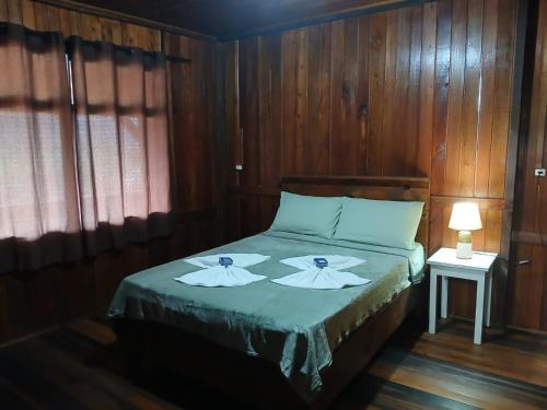 a bedroom with a bed with wooden walls at Casas particulares Heil e Abadir in Urubici