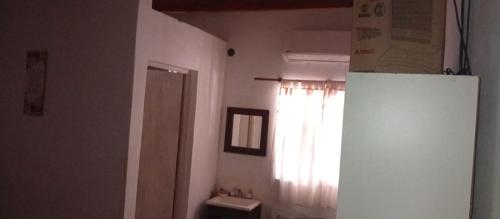 a kitchen with a white refrigerator and a window at El Shaddai Hospedaje Temporal in Santiago del Estero