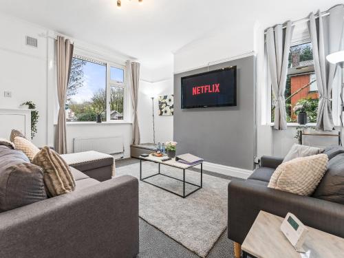 a living room with two couches and a tv at Crew Quarters - Your Ideal Stay in Bury in Tottington