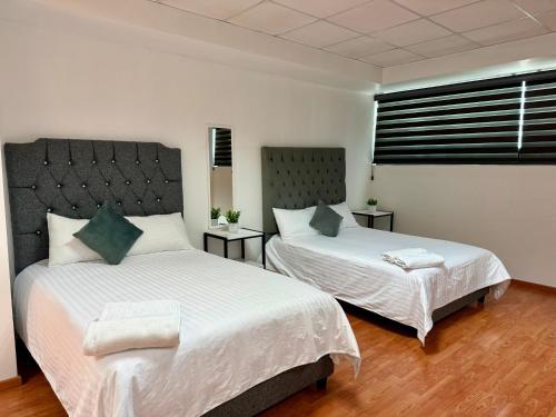 een slaapkamer met twee bedden en een raam bij Tiny Rooms in Toluca