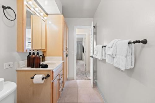 a bathroom with a sink and a toilet and a mirror at Ocean View from Lanais-2 Blocks to Waikiki Beach in Honolulu