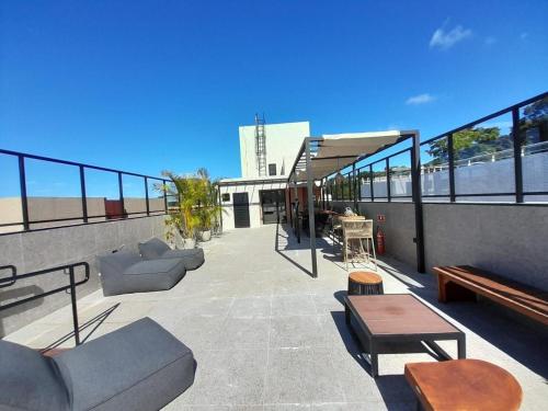 a rooftop patio with couches and tables on a building at Aurea 310 in Tambaú