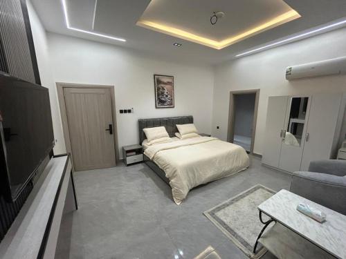 a bedroom with a bed and a tv and a couch at قمرة قباء Quba moon3 in Al Madinah