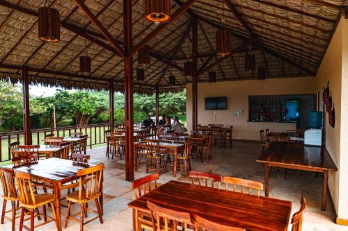 een leeg restaurant met houten tafels en stoelen bij Hotel Via Do Sol Eco Chalés in Trairi