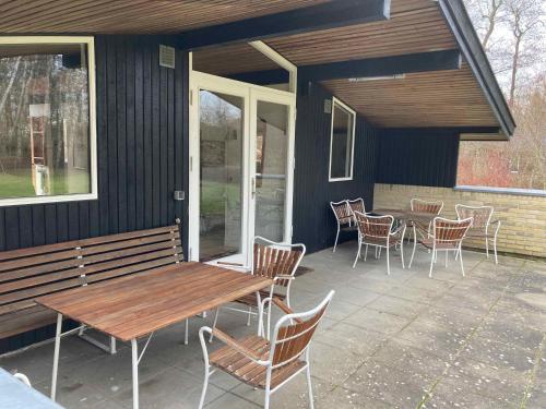 d'une terrasse avec un banc en bois, des chaises et une table. dans l'établissement Nostalgic 1960S Idyll, à Hornsved