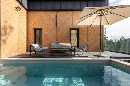 a house with a swimming pool and an umbrella at 3 Tačke Tara in Zaovine