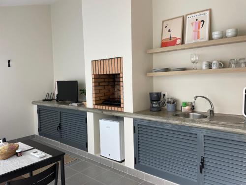 a kitchen with blue cabinets and a counter with a sink at Casa da Mónica in Ponta Delgada