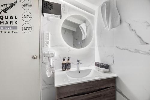 クイーンズタウンにあるLakeview Colonial Motelの洗面台と鏡のある白いバスルーム