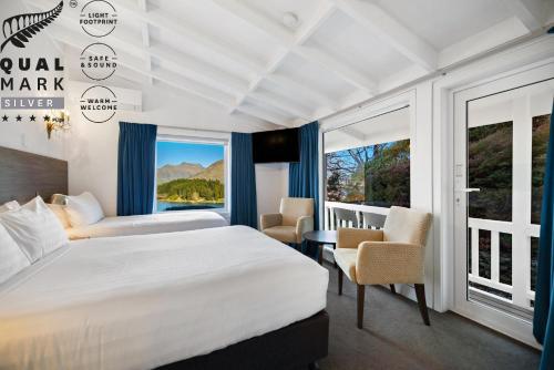 クイーンズタウンにあるLakeview Colonial Motelのベッドと大きな窓があるホテルの部屋