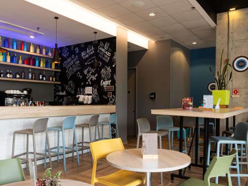 um restaurante com mesas, cadeiras e um bar em ibis Chia em Chía