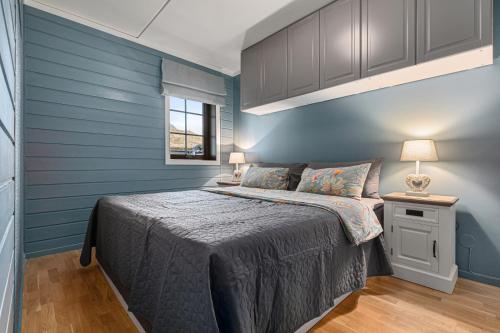 Un dormitorio azul con una cama y una ventana. en Norefri - Norefjell, en Ørpen