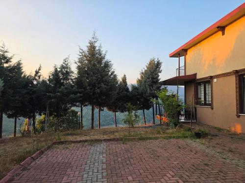 a house with a brick driveway next to a building at House overlooking a lake 