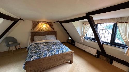 ein Schlafzimmer mit einem Bett und zwei Fenstern in der Unterkunft Danegelts Waveney Marshes Bed & Breakfast in Geldeston