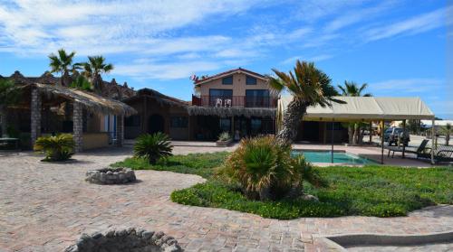 a house with palm trees in front of a building at Little Slice of Heaven - Amazing San Felipe Beach Rental in Don Pancho