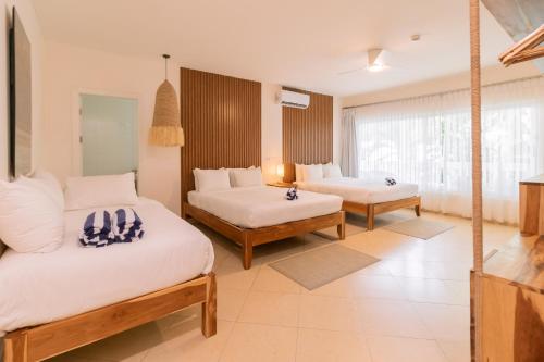 a bedroom with two beds and a large window at Hotel Santa Teresa by the Beach in Santa Teresa Beach