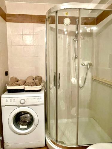 a shower and a washing machine in a bathroom at Ski&Sky Studiò 85 in Pila