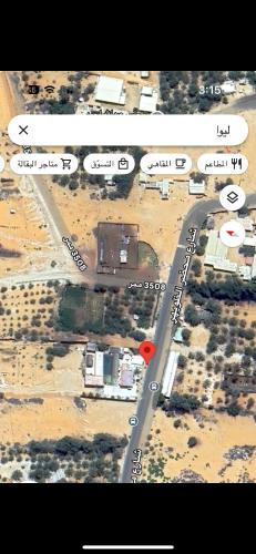 an overhead view of a road with a red dot at استراحة رملة ليوا in Al Aţīr