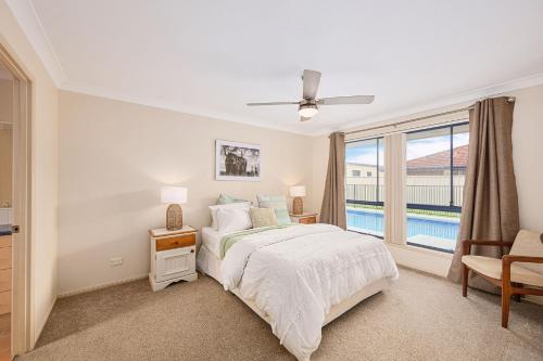 a bedroom with a bed and a large window at The Drift at Cathie in Lake Cathie