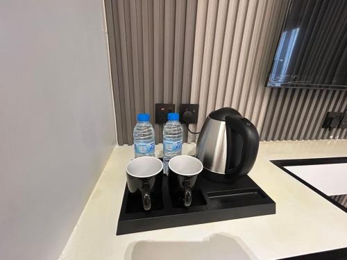 a counter with two bottles of water and two cups at قمرة قباء Quba moon5 in Al Madinah